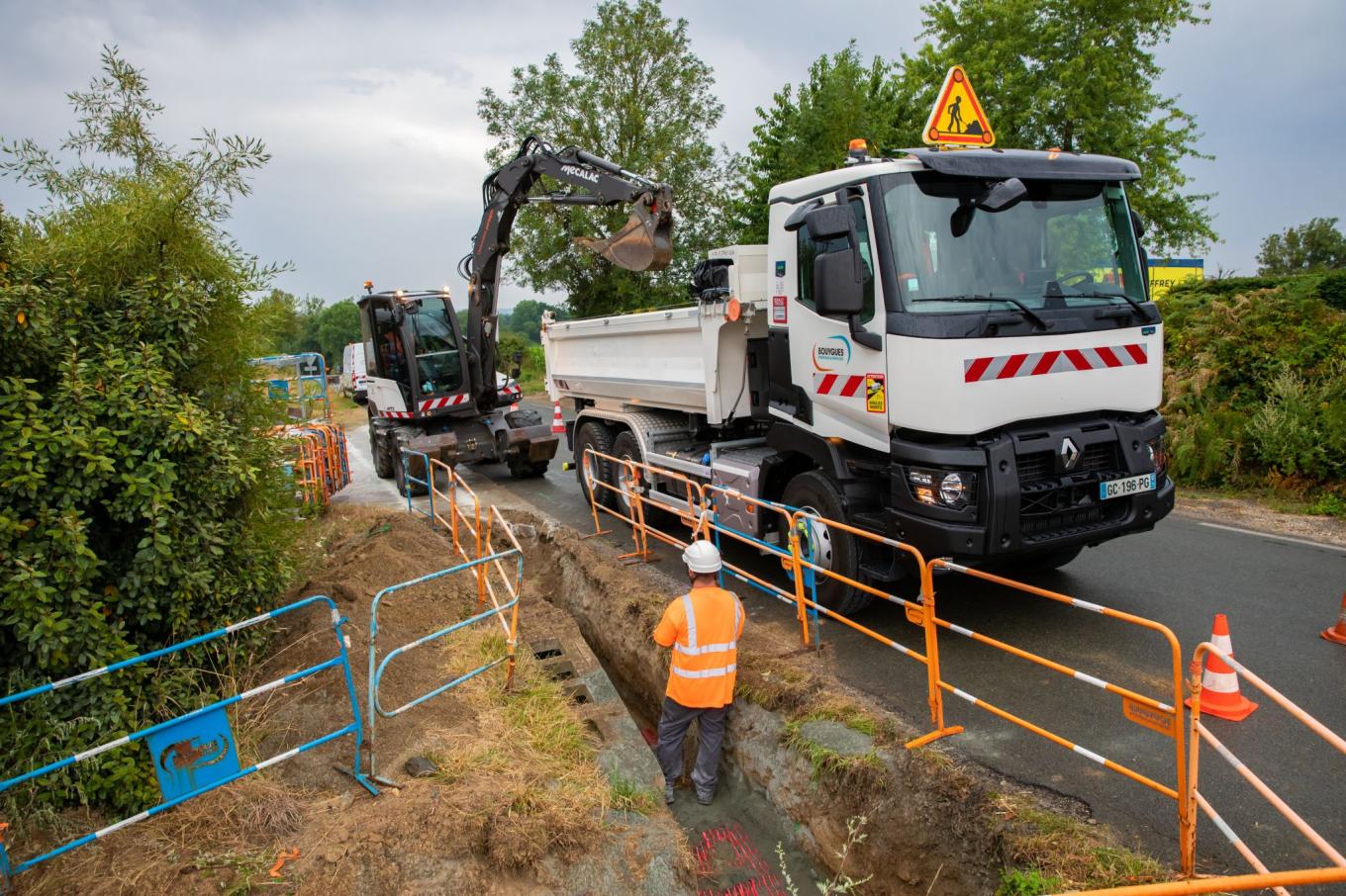 Un homme dans une tranchée travaillant sur des réseaux électriques