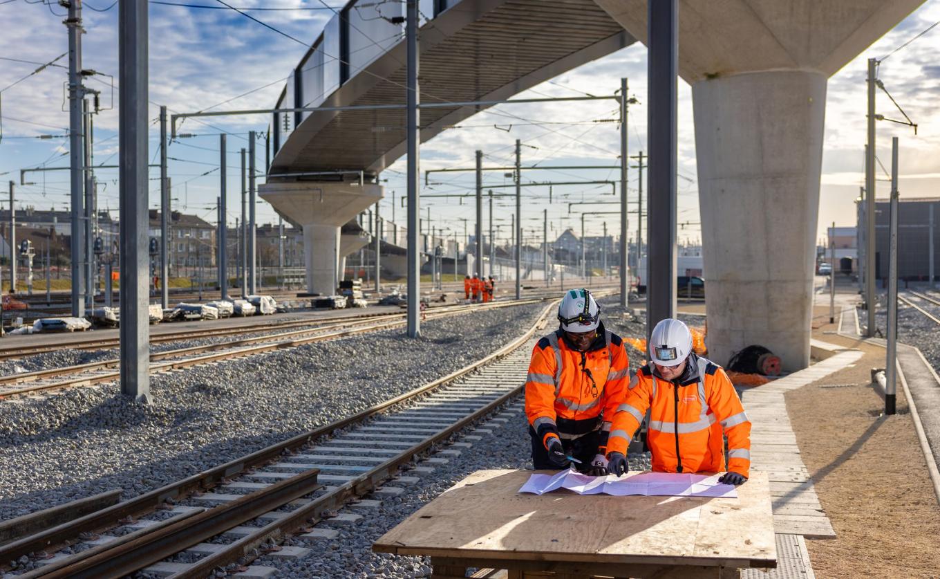 Hommes qui regarde un plan à côté d'une ligne du RER E