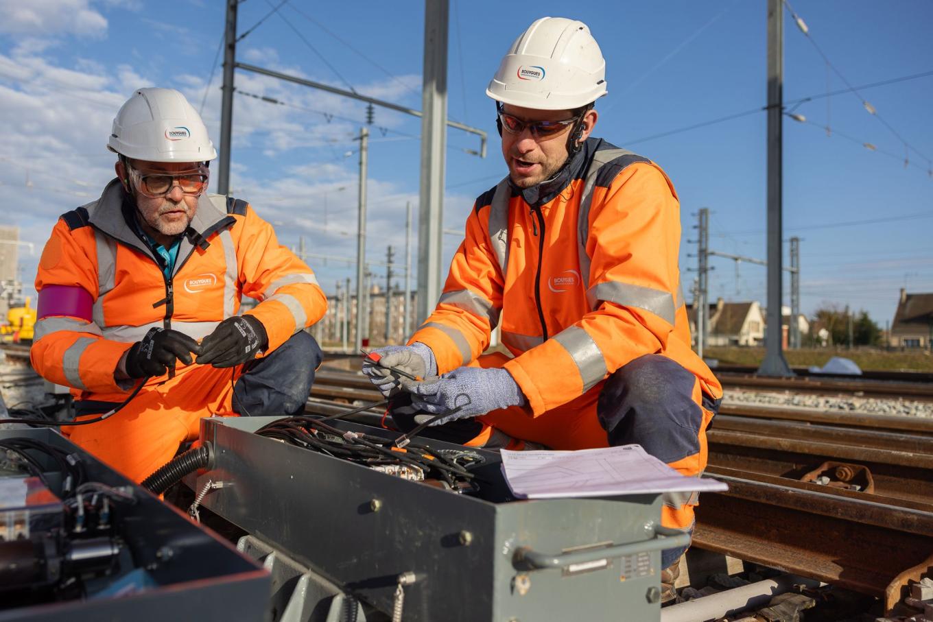 Hommes qui regarde un plan à côté d'une ligne du RER E